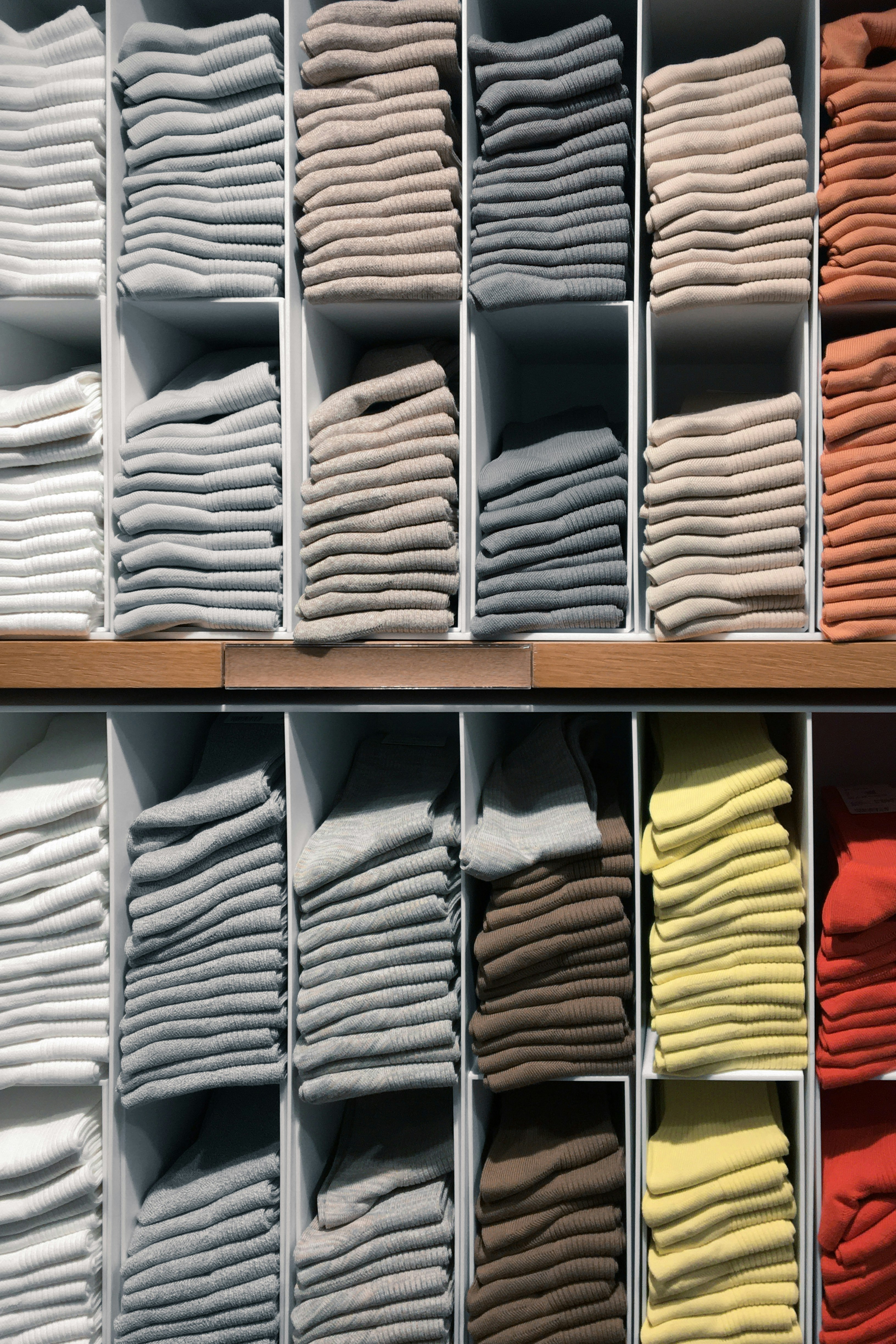 white and yellow textiles on brown wooden shelf